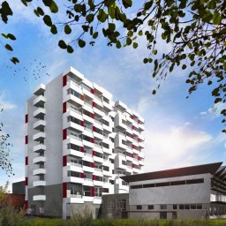 Jagoda Lotz Architektura - Wizualizacja budynku mieszkalnego wielorodzinnego z czerwonymi akcentami, widok z dołu przez gałęzie drzew, na tle błękitnego nieba z ptakami.