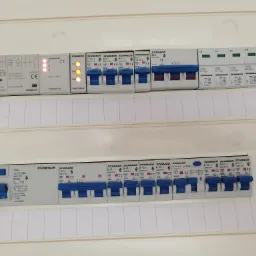 Rozdzielnica elektryczna z zainstalowanymi bezpiecznikami i wyłącznikami różnicowoprądowymi marki Schrack, widoczne oznaczenia i parametry techniczne.