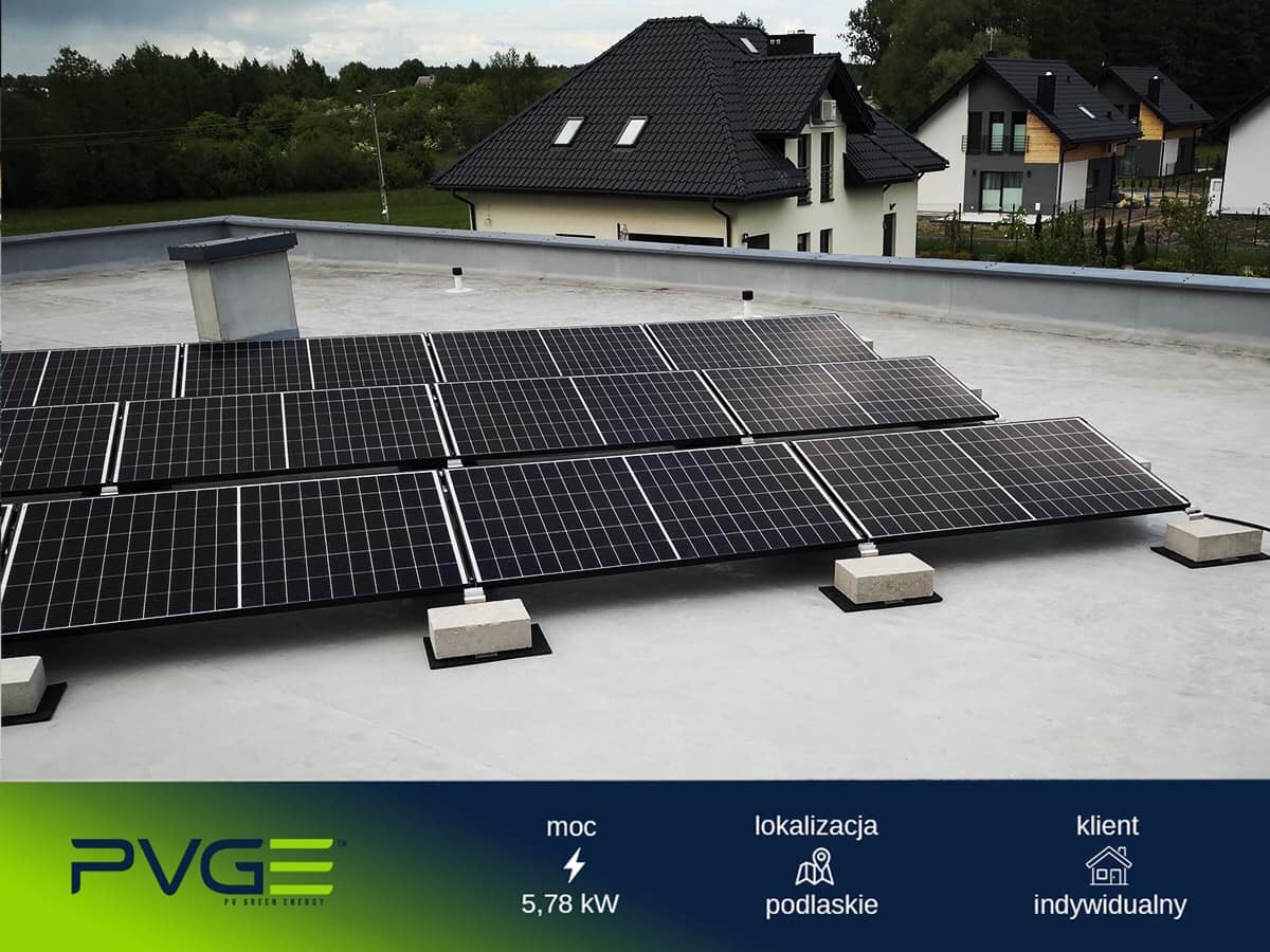 Panele słoneczne na płaskim dachu domu jednorodzinnego, betonowe podstawy, widok z góry, Podlaskie.