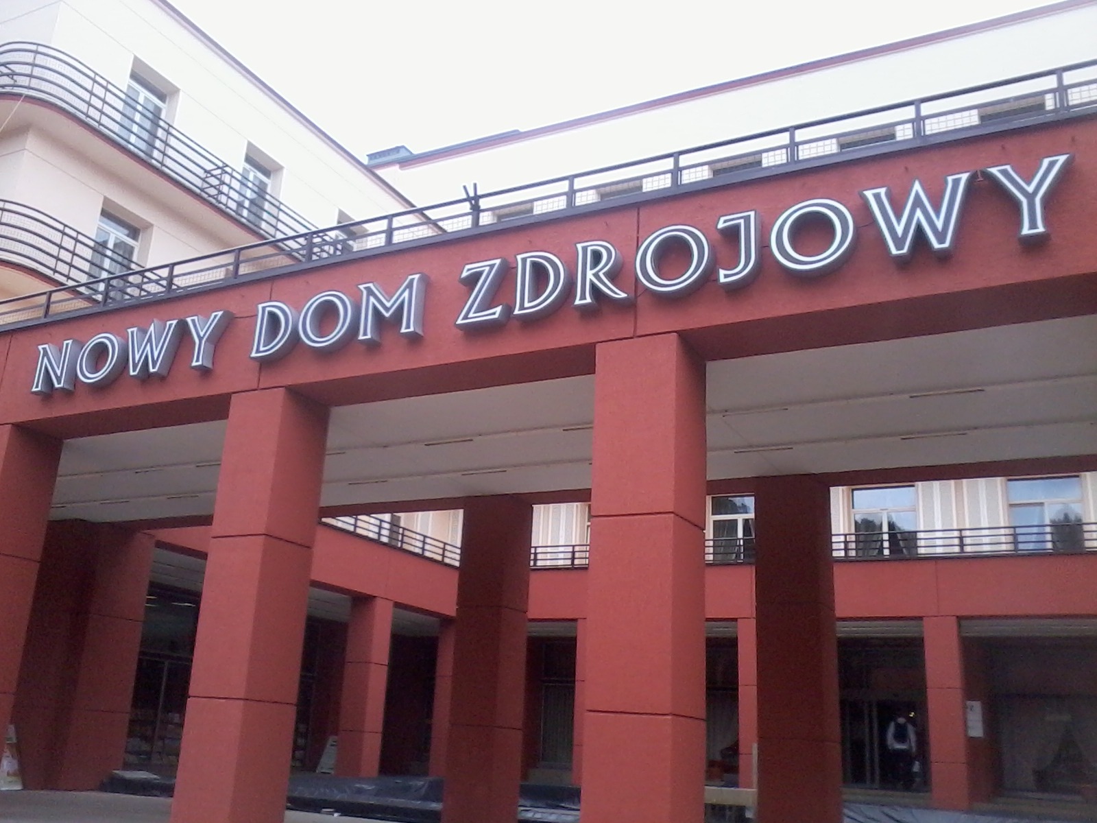Elewacja budynku Nowy Dom Zdrojowy z dużym napisem w kolorze srebrnym, widok z dołu.