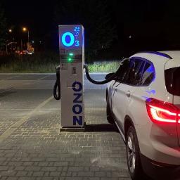 O-ZONIC sp. z o.o - Samochód podłączony do stacji ozonowania pojazdów na zewnątrz w nocy, widoczny napis O3 i logo OZONO.