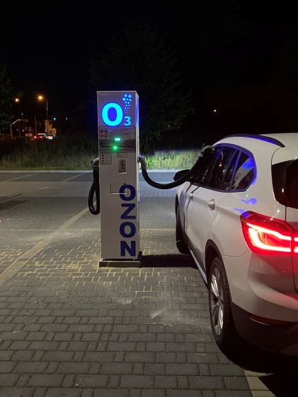 Samochód podłączony do stacji ozonowania pojazdów na zewnątrz w nocy, widoczny napis O3 i logo OZONO.