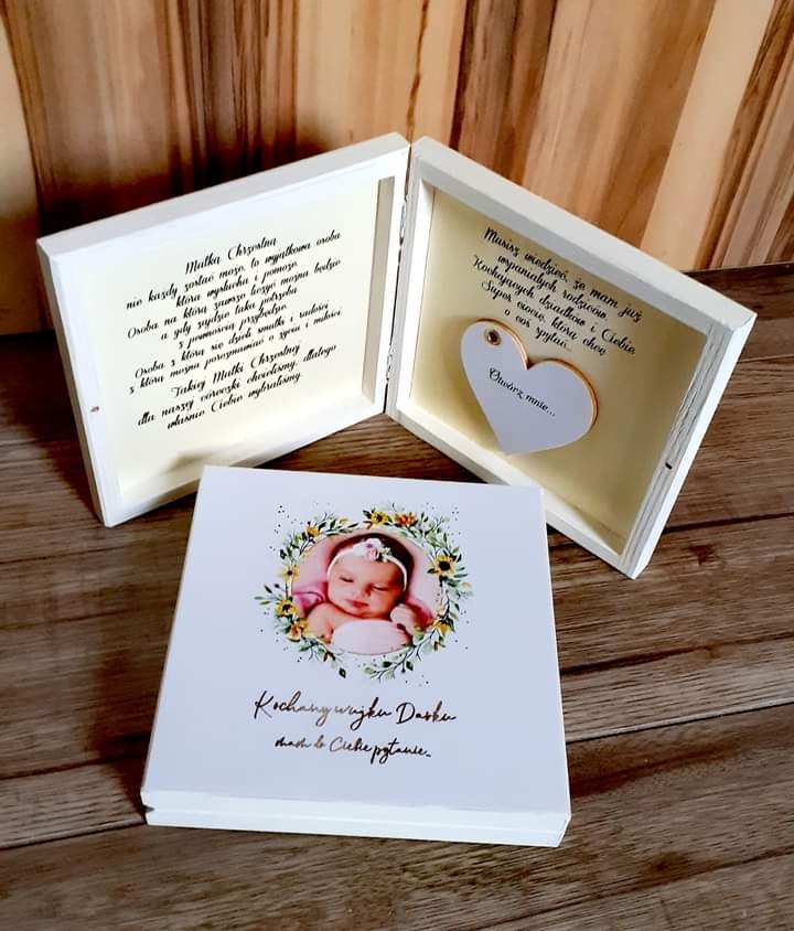 Trzy białe, drewniane pudełka prezentowe z personalizowanymi napisami i zdjęciem dziecka, ułożone na drewnianym podłożu.