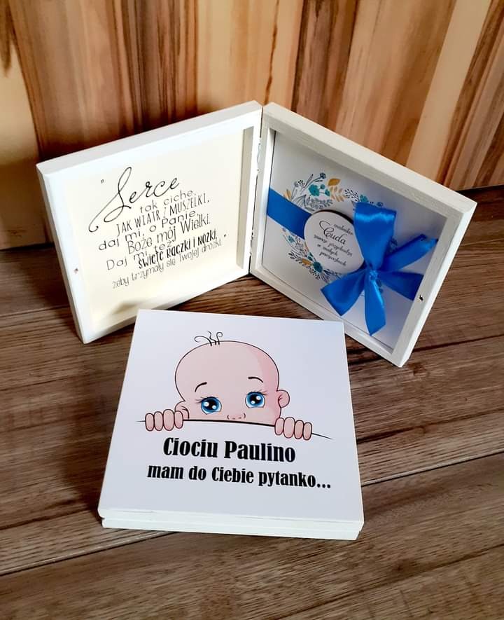 Ręcznie robione pudełka z dedykacjami i niebieską wstążką, oraz kartka z napisem 'Ciociu Paulino mam do Ciebie pytanko...' i rysunkiem dziecka, na drewnianym tle.