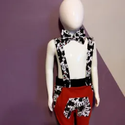 Ubranko dziecięce z motywem Myszki Miki: czerwone spodnie z kieszeniami, szelki i mucha na manekinie, tło fioletowo-szare.