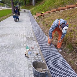 Budowa chodnika z kostki betonowej oraz przykrycie cieku wodnego kratami kompozytowymi 