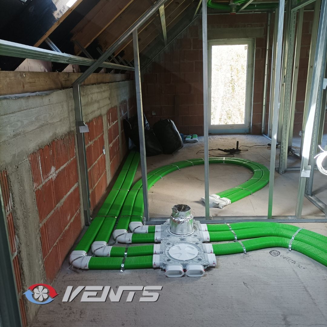 Wnętrze w trakcie montażu instalacji wentylacyjnej z zielonymi przewodami w Rybniku, widoczne surowe ściany i metalowa konstrukcja szkieletowa.