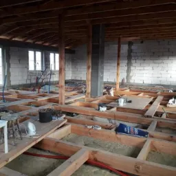 Konstrukcja drewniana podłogi na poddaszu w Więcborku, widoczne instalacje, ściany z białego pustaka, przygotowanie do ocieplenia.