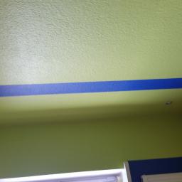 Stanisław Napierała - Ściana i sufit pomalowane na zielono z poziomym, niebieskim pasem dekoracyjnym w Żninie. Widoczny fragment ściany wyłożonej boazerią.