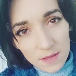 Portret kobiety z kolczykiem w nosie we Wrocławiu, ubrana w niebieski sweter z golfem.