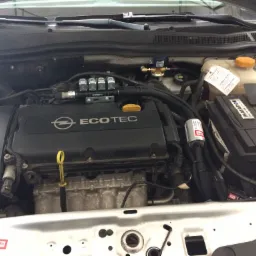 Silnik Opel Ecotec z widoczną instalacją gazową BRC, w tym reduktor i wtryskiwacze, oraz etykieta informująca o wymianie oleju.