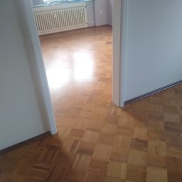 Raf -Tob remontujemy - Parkiet ułożony w kwadraty, widoczny z perspektywy przejścia między pokojami. W tle biały grzejnik i ściana w jasnym odcieniu fioletu.