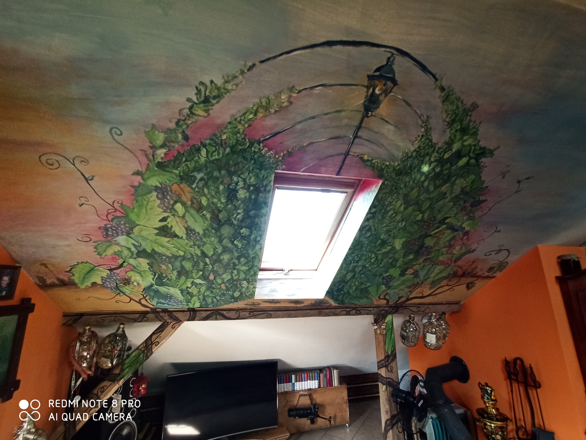 Malowidło na suficie przedstawiające iluzję tunelu z roślinnością i latarnią, otaczające okno dachowe.