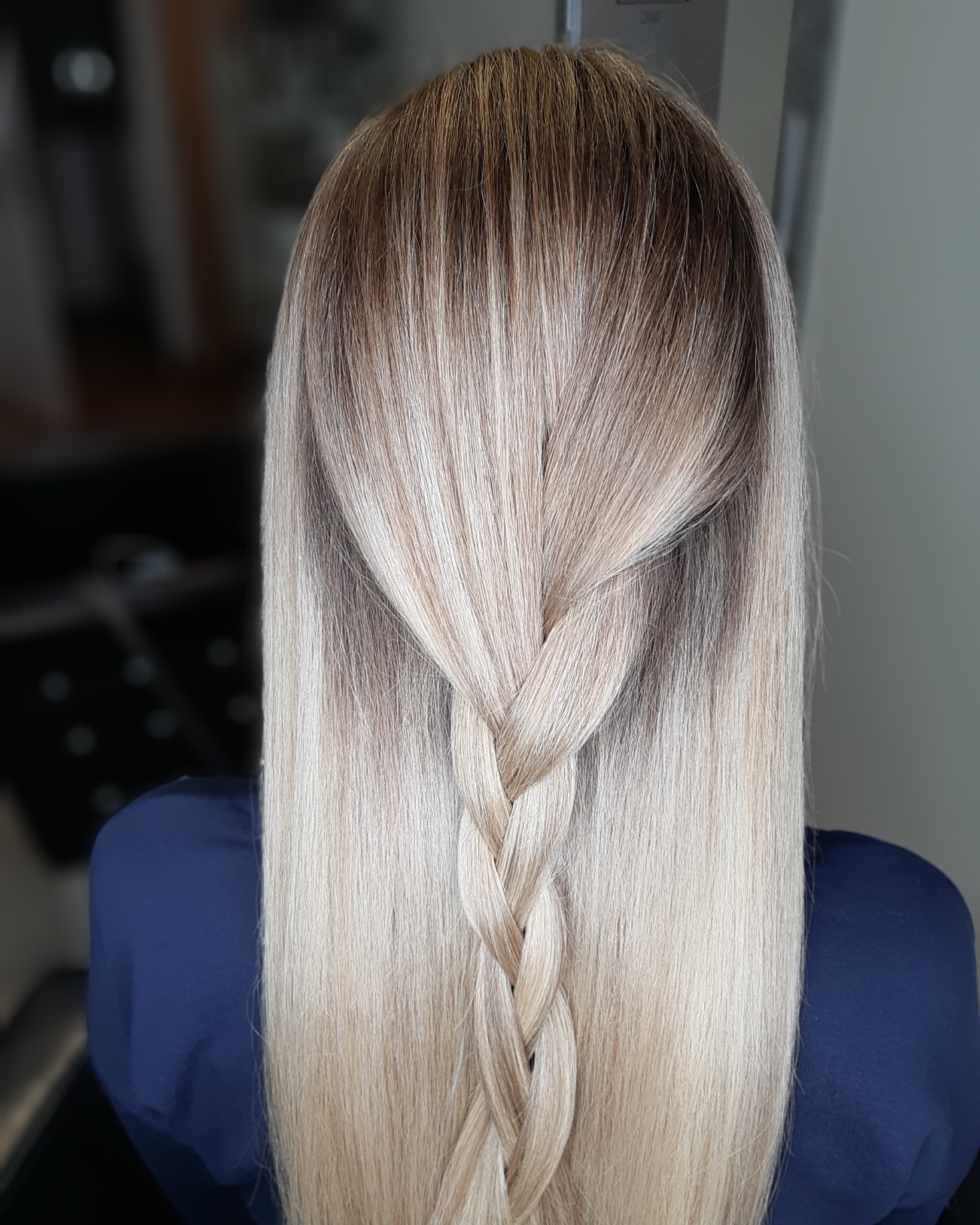 Tył głowy z długimi, prostymi włosami ombre blond, zaplecionymi w warkocz francuski od połowy długości.