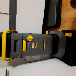 Profesjonalny odkurzacz piorący Karcher Puzzi 30/4 C w kolorze szaro-czarnym z żółtymi akcentami, ustawiony na podłodze z paneli, widoczny z boku, z naklejką z danymi technicznymi.