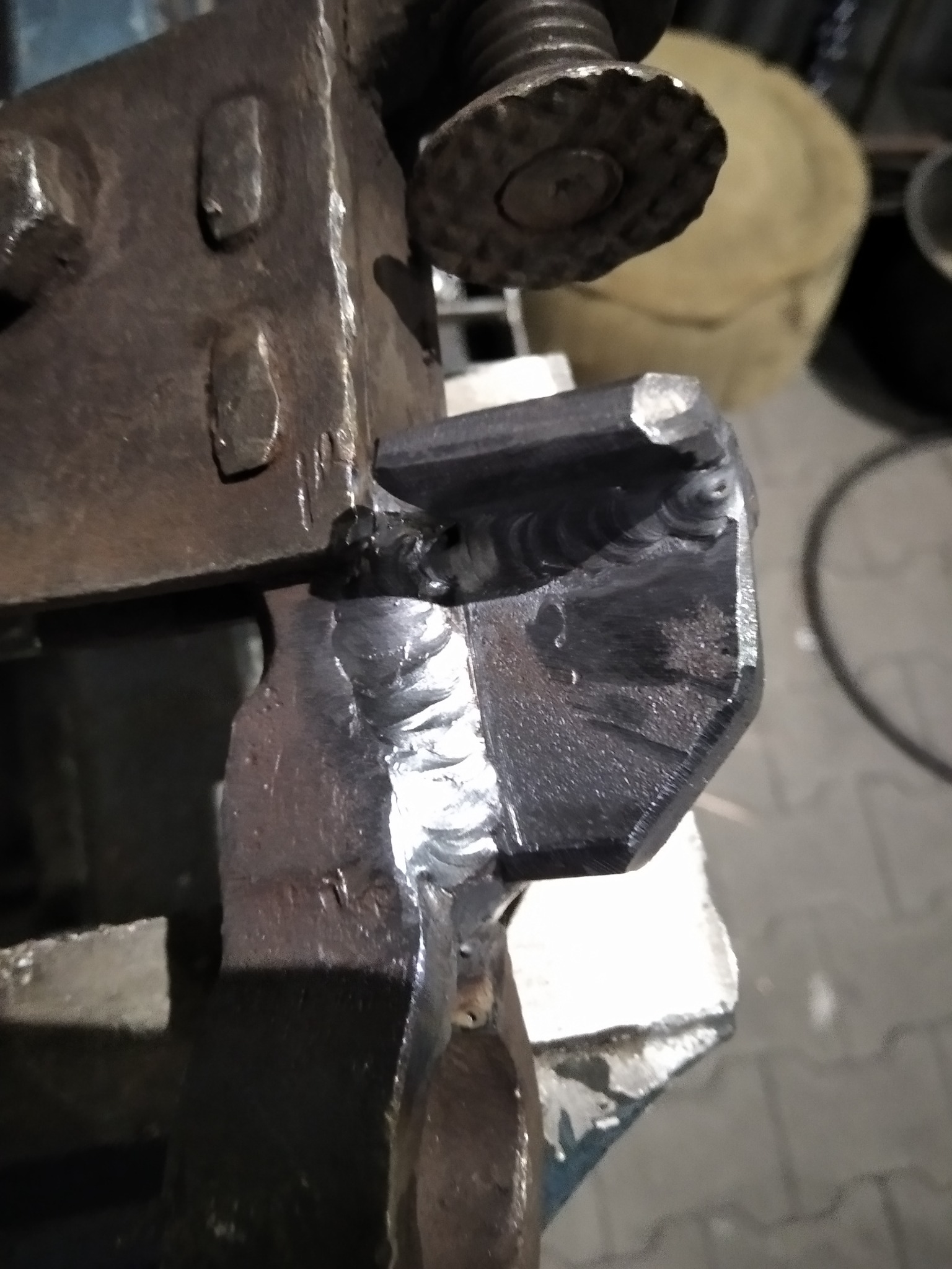 Spoina łącząca dwa metalowe elementy w uchwycie, widoczne ślady obróbki i struktura metalu.