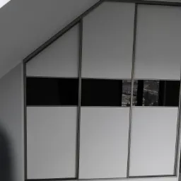 Szafa wnękowa z przesuwnymi drzwiami, białe panele i czarne pasy, dopasowana do skosu dachu, widoczne narzędzia montażowe.