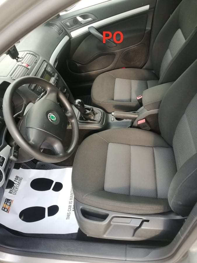 Wnętrze samochodu w Barcinie z szarymi fotelami i papierową matą podłogową z nadrukowanymi śladami stóp.