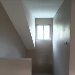 Poddasze po malowaniu na jednolity, jasny kolor, z widocznym oknem i przygotowanymi punktami elektrycznymi.