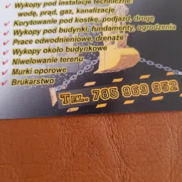 Wizytówka firmy budowlanej z wykazem usług: wykopy pod instalacje, korytowanie, wykopy pod budynki, prace odwodnieniowe, niwelacja terenu, murki oporowe, brukarstwo oraz ilustracją koparki...