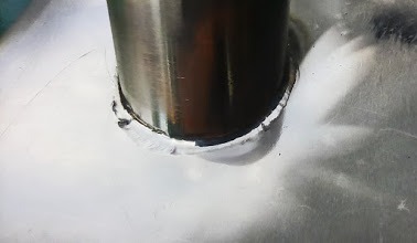 Detal spoiny łączącej okrągły, metalowy słupek z płaską powierzchnią. Widoczny nierówny ślad spawania.