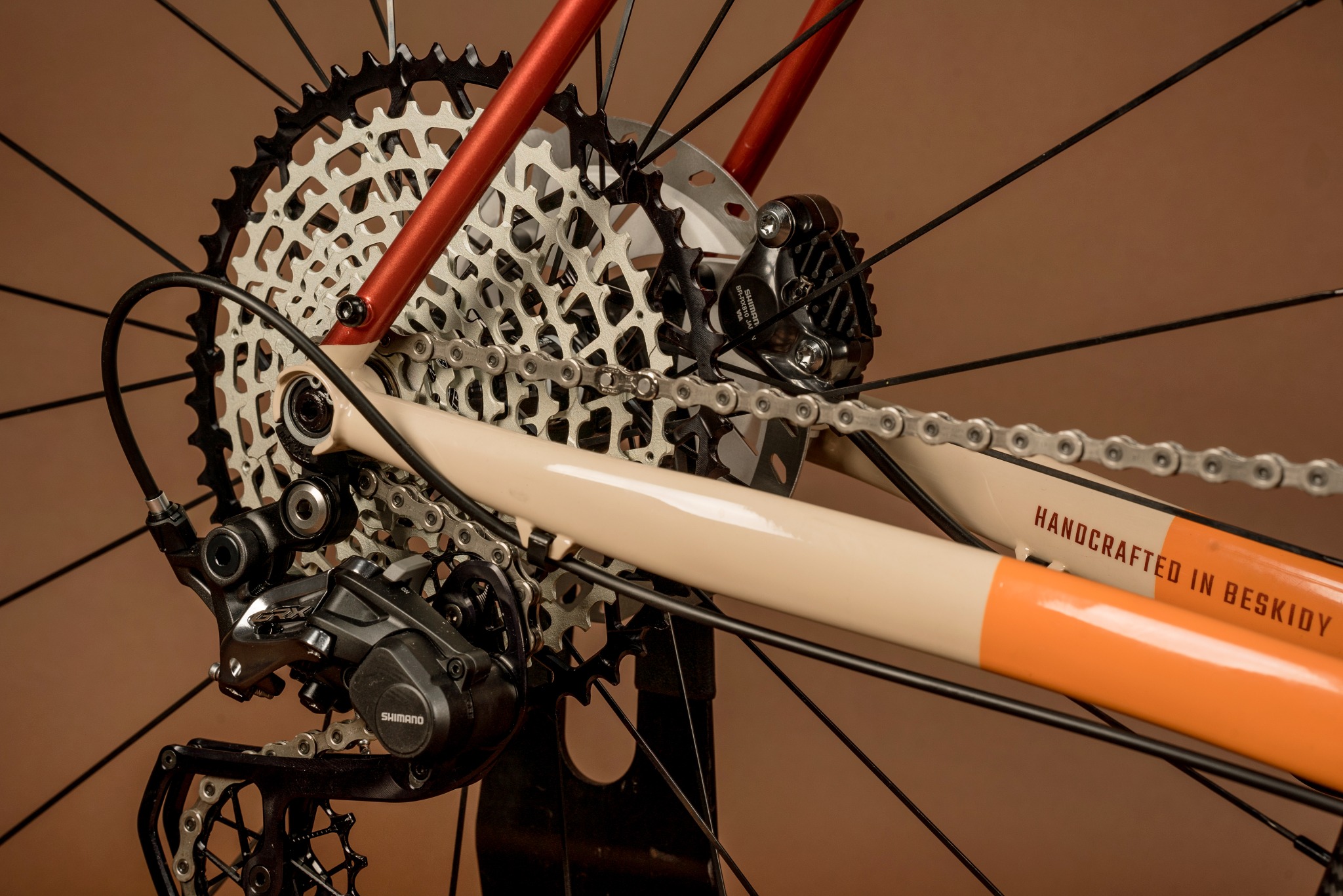 Szczegółowy widok tylnej przerzutki Shimano GRX i kasety roweru z napisem 'Handcrafted in Beskidy' na ramie.