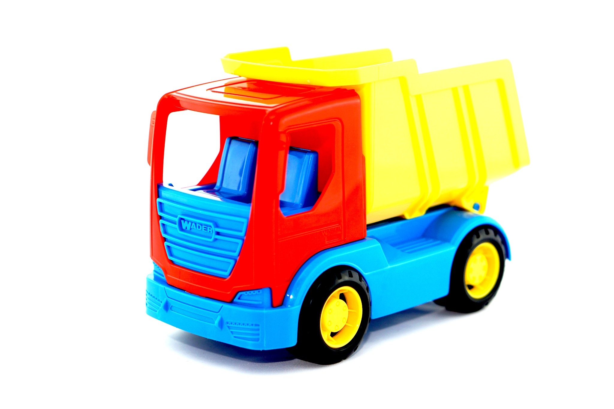 Plastikowa zabawka - wywrotka w kolorach czerwonym, niebieskim i żółtym, z widocznym logo 'Wader' na kabinie, ustawiona na białym tle.