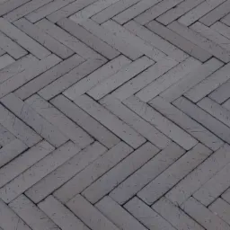 Ułożona w jodełkę szara kostka brukowa, widok z góry, widoczne drobne rysy na powierzchni kostki.