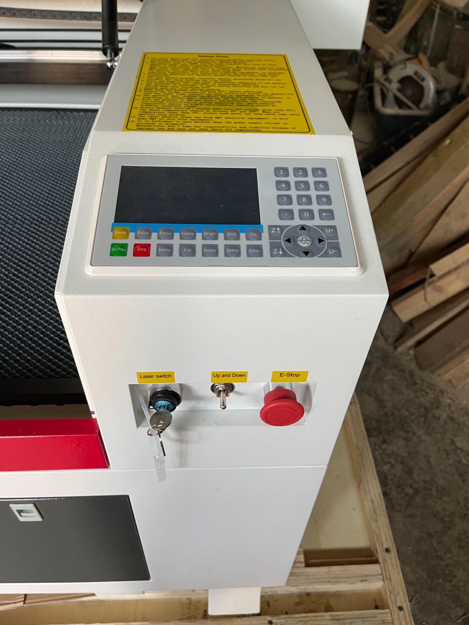 Panel sterowania maszyny do obróbki metali w Bielsko-Białej, z widocznym ekranem, klawiaturą numeryczną, przyciskami funkcyjnymi, wyłącznikiem bezpieczeństwa (E-Stop) i kluczykiem w stacyjce.