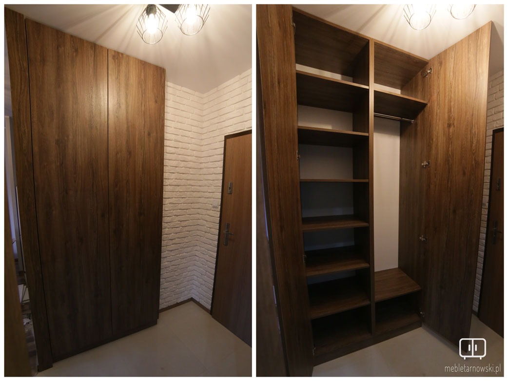 Brązowa, drewnopodobna szafa wnękowa z otwartymi drzwiami, ukazująca półki i drążek na ubrania, na tle ściany z białej cegły.