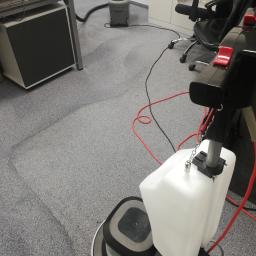 Mobilna Para Marcin Ocipka - Maszyna do czyszczenia dywanów w biurze, widoczne ślady czyszczenia na szarym dywanie, w tle biurko i krzesło biurowe.