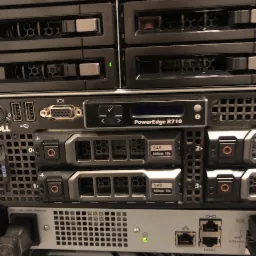 Serwer Dell PowerEdge R710 z dyskami SAS 600GB 10K RPM w szafie rack, widoczne porty Ethernet i zasilanie, zielone diody LED wskazują status pracy.