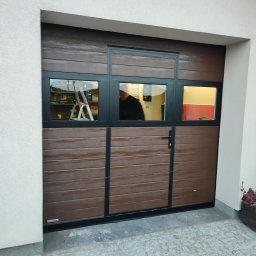 Brama garażowa z drzwiami serwisowymi i panelem szklanym.