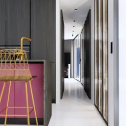 Wnętrze nowoczesnej kuchni z dwoma złotymi krzesłami barowymi przed różową wyspą kuchenną, ciemnymi szafkami w tle i widokiem na korytarz z dekoracyjną ścianą z mapą.