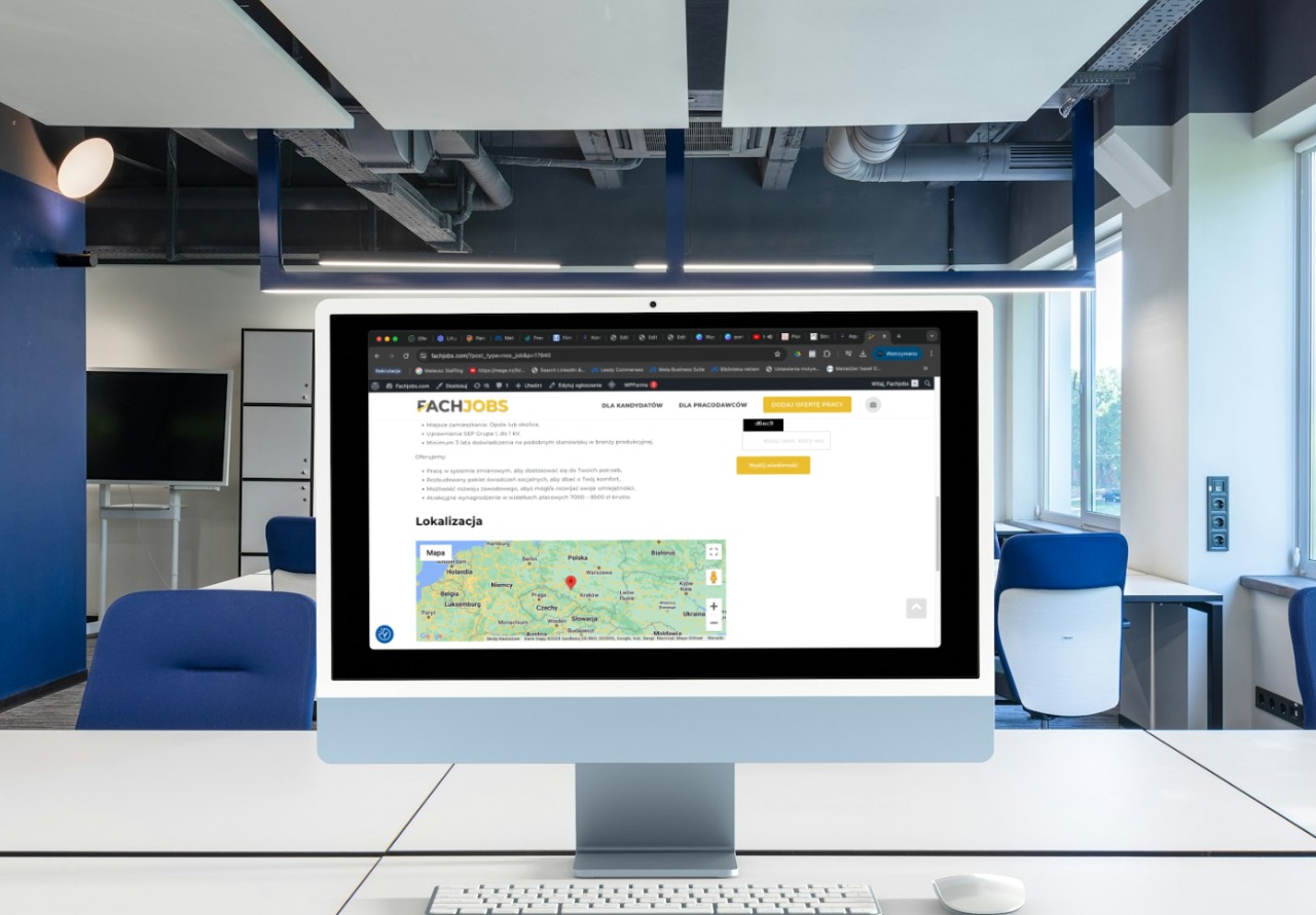 Monitor iMac wyświetlający stronę internetową Fachjobs w nowoczesnym biurze z niebieskimi akcentami i białymi meblami.