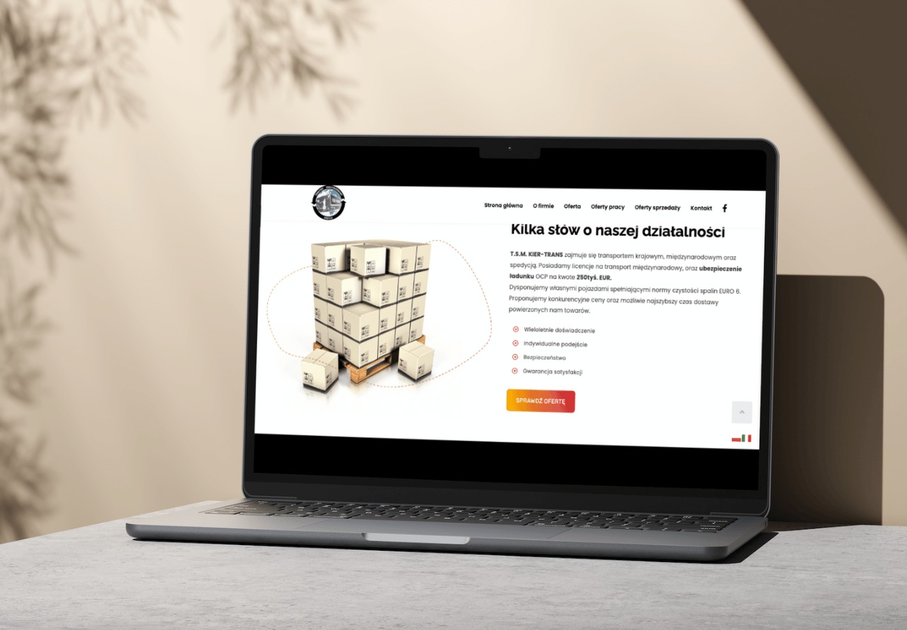 Laptop wyświetla stronę internetową firmy transportowej z grafiką ułożonych kartonów na palecie, podkreślając usługi transportu krajowego i międzynarodowego.