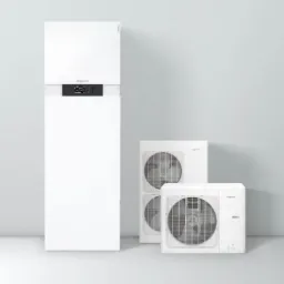 Biała, nowoczesna instalacja grzewcza z dwoma zewnętrznymi jednostkami wentylacyjnymi na tle szarej ściany. Widoczny panel sterowania z wyświetlaczem.