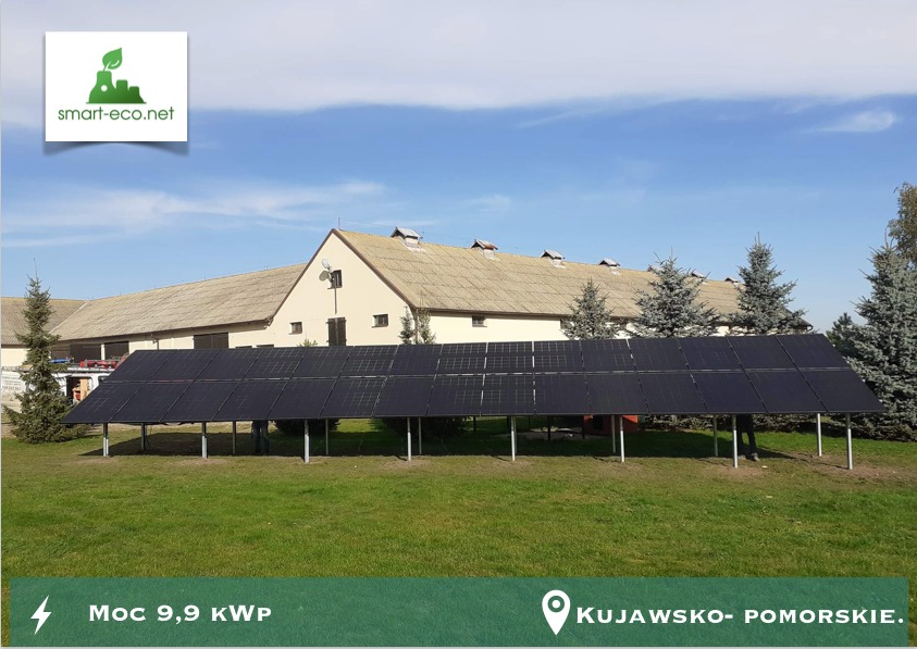 Instalacja paneli słonecznych na metalowej konstrukcji na tle budynku gospodarczego i drzew iglastych, z informacją o mocy 9,9 kWp i lokalizacji Kujawsko-Pomorskie.