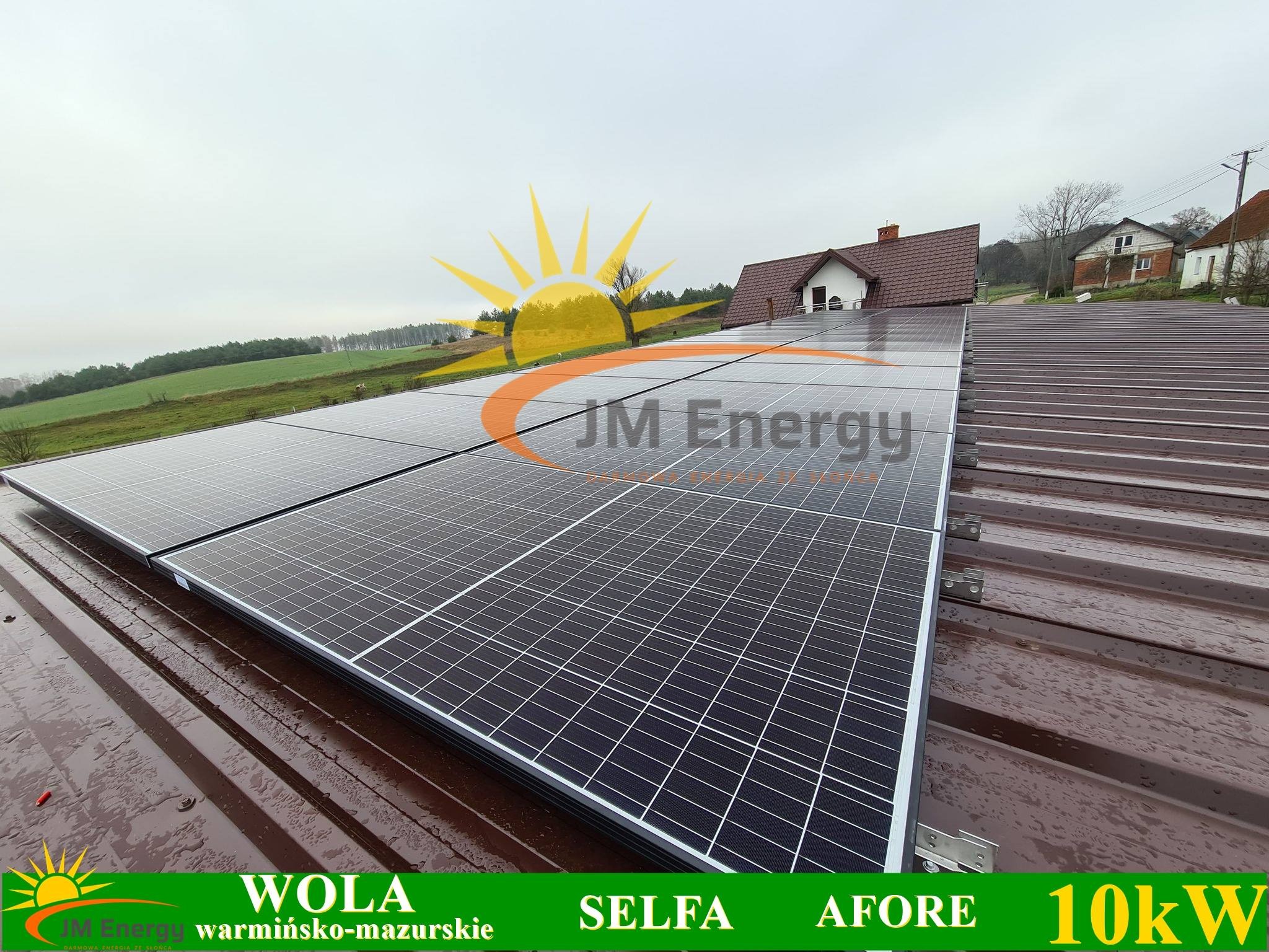 Panele słoneczne na brązowym dachu domu jednorodzinnego, widok z bliska, częściowo pochmurne niebo w tle.