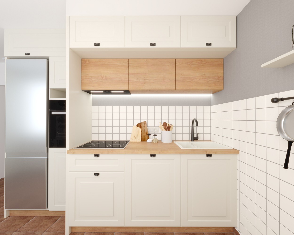 Jasna kuchnia z białymi szafkami i drewnianym blatem, okapem i płytą grzewczą, na ścianie białe kwadratowe płytki, widoczny fragment lodówki i wisząca patelnia