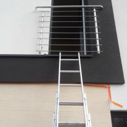 Luk-Spaw - Montaż zewnętrznej balustrady ze stali nierdzewnej na balkonie, widoczna drabina oparta o ścianę budynku.