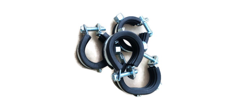 Metalowe obejmy z gumową wyściółką, skręcane śrubami i nakrętkami, leżące na białym tle.