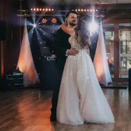 Para młoda w tańcu na parkiecie, w tle scena z nagłośnieniem i oświetleniem, kolumny głośnikowe Yamaha.