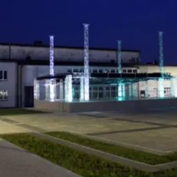 Zewnętrzny widok oświetlonej, ruchomej sceny o konstrukcji aluminiowej na rynku w Radzionkowie, sfotografowanej nocą.