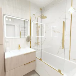 Wizualizacja łazienki z beżową szafką pod umywalką, podświetlanym lustrem i kabiną prysznicową ze złotymi elementami na tle marmurowych płytek z złotymi żyłami.