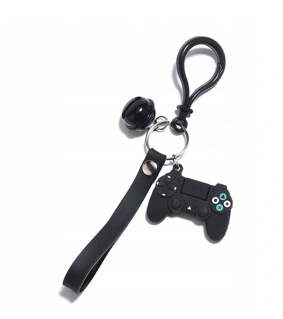 Czarny brelok z zawieszką w kształcie kontrolera do gier, z czarnym paskiem i małą czarną kulką, zawieszony na metalowym kółku i karabińczyku na jasnym tle.