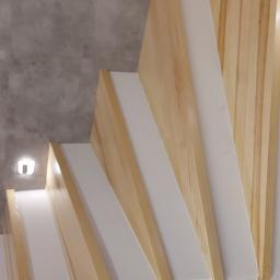 NowaMal Krzysztof Nowakowski Wykończenia Remonty Stolarstwo - Nowoczesne schody drewniane z białymi podstopnicami, widok z dołu, oświetlenie punktowe na ścianie z szarymi płytkami.