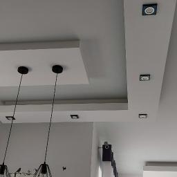 NowaMal Krzysztof Nowakowski Wykończenia Remonty Stolarstwo - Wielopoziomowy sufit podwieszany z płyt kartonowo-gipsowych z oświetleniem punktowym i wiszącymi lampami, dekoracyjna ściana z cegły.