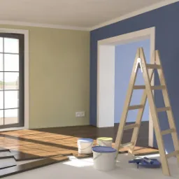 Pokój w trakcie odnawiania: częściowo pomalowana ściana na niebiesko, drewniana drabina, wiaderka z farbą, wałek malarski, panele podłogowe w promieniach słońca padających z okna balkonowego.