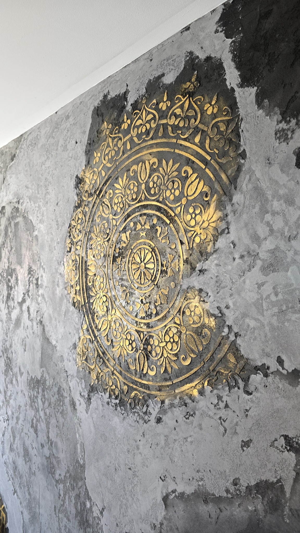 Dekoracyjna ściana z efektem stiuku i złotym ornamentem w Bydgoszczy. Unikalna faktura i wzór nadają wnętrzu elegancji. Wykończenie z dbałością o detale.